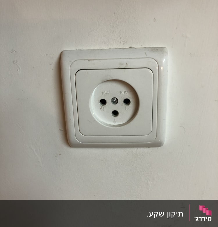 שקע חשמל לבן בקיר עם שלושה חורים